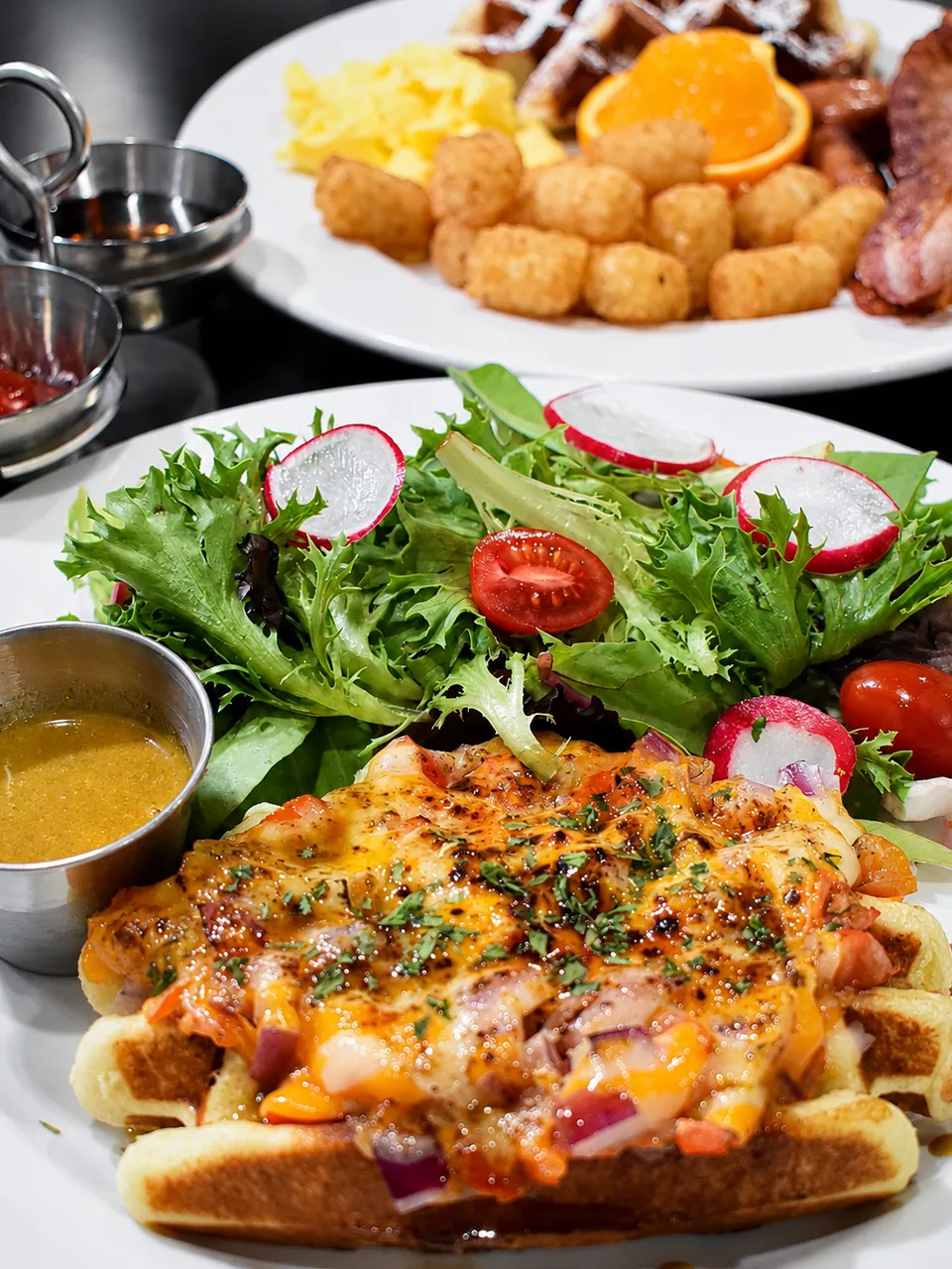 A savoury waffle with sauce and a fresh side salad