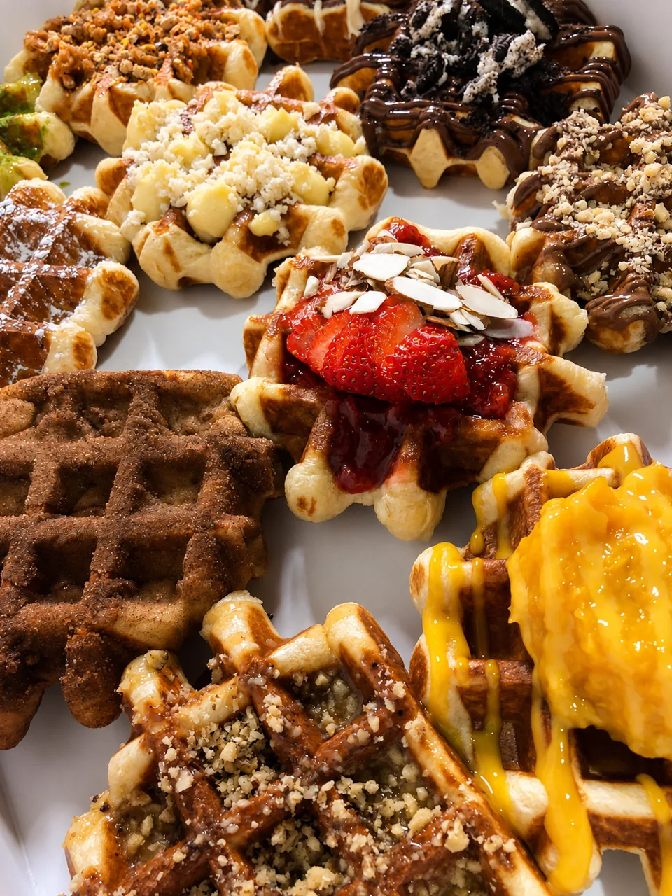 An assortment of Belgian waffles with colourful sweet toppings